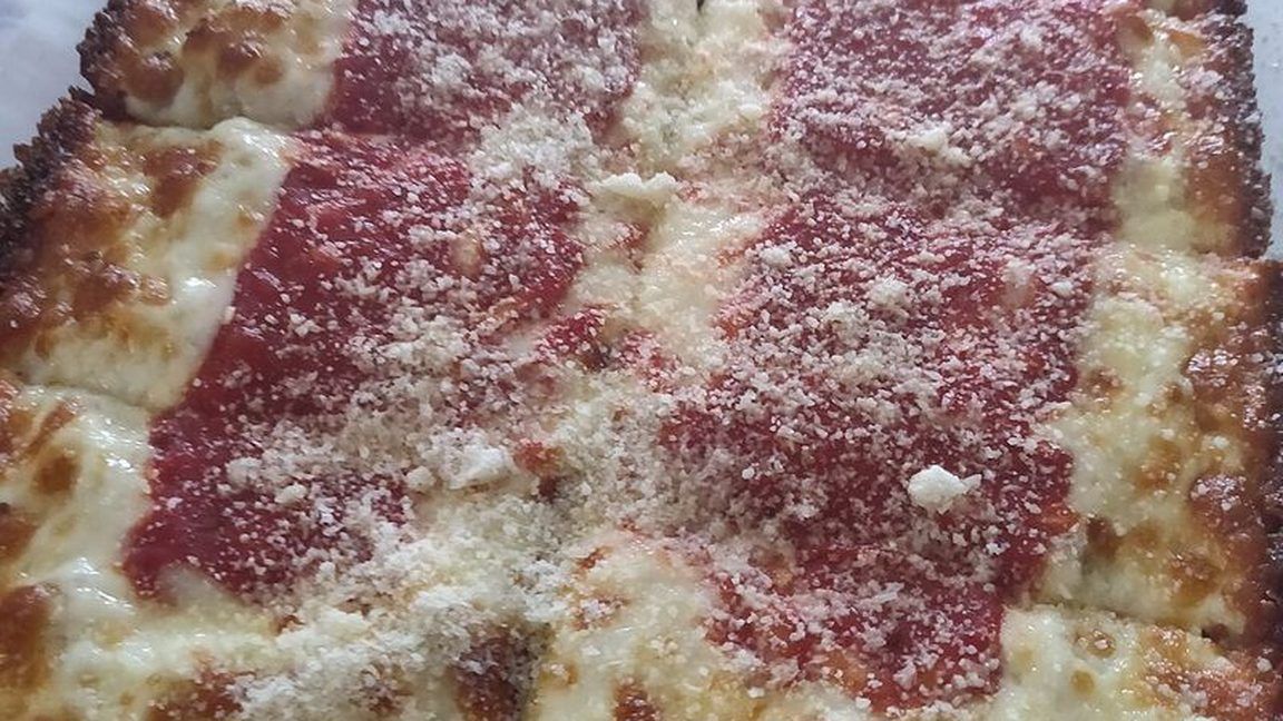 A square Detroit style pizza with crispy, cheesy edges